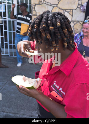 dh St. George GRENADA CARIBBEAN Frau Aushöhlungen in Fleisch Von Kokosnussmenschen einheimische Mädchen, die Kokosnüsse essen Stockfoto