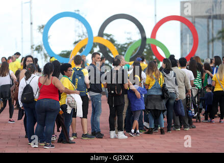 Fans stehen Schlange, um ihre Fotos neben den olympischen Ringen im Olympiapark am siebten Tag der Olympischen Spiele in Rio, Brasilien, machen zu lassen. Bilddatum: Freitag, 12. August 2016. Bildnachweis sollte lauten: David Davies/PA Wire. Stockfoto