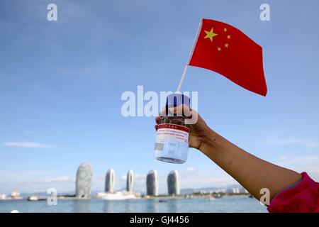 (160812)--SANYA, 12. August 2016 (Xinhua)--ein Forscher zeigt Wasserprobe aus Tiefsee auf Chinas Tiefsee Tauchpumpe Mutterschiff, Tansuo-1, in Sanya, Hainan Provinz Süd-China, 12. August 2016. Tansuo-1 kehrte nach Sanya am Freitag nach Abschluss seiner erfolgreichen Jungfernfahrt nach Mariana Trench. Das Mutterschiff durchgeführt 60 Wissenschaftler und Besatzung sowie ein 10.000-Meter-autonome ferngesteuerte Tauchpumpen, ein 9.000 Meter Meeresboden Seismometer und Geräte im Inland hergestellt. Es verließ Sanya am 22. Juni für die Mariana Trench-Expedition. (Xinhua/Jin Liwang) (Wyl) Stockfoto