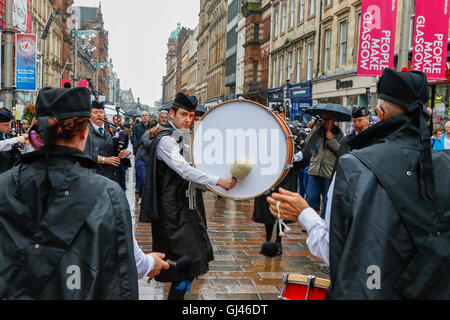 Glasgow, UK. 12. August 2016. Trotz starkem Regen und starkem Wind einige Touristen noch stellte sich heraus, dass die Pipe Bands, gab kostenlose Konzerte auf dem George Square und rund um die Innenstadt zu unterstützen. Die einwöchige Festival der Dudelsack Musik endet am Samstag mit dem spektakulären Welt Pipeband Meisterschaft, an der alle Bands. Credit: Findlay/Alamy leben Nachrichten Stockfoto