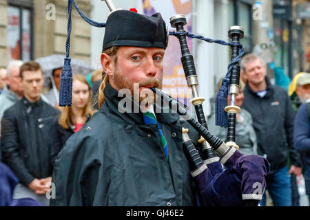 Glasgow, UK. 12. August 2016. Trotz starkem Regen und starkem Wind einige Touristen noch stellte sich heraus, dass die Pipe Bands, gab kostenlose Konzerte auf dem George Square und rund um die Innenstadt zu unterstützen. Die einwöchige Festival der Dudelsack Musik endet am Samstag mit dem spektakulären Welt Pipeband Meisterschaft, an der alle Bands. Credit: Findlay/Alamy leben Nachrichten Stockfoto