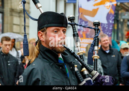 Glasgow, UK. 12. August 2016. Trotz starkem Regen und starkem Wind einige Touristen noch stellte sich heraus, dass die Pipe Bands, gab kostenlose Konzerte auf dem George Square und rund um die Innenstadt zu unterstützen. Die einwöchige Festival der Dudelsack Musik endet am Samstag mit dem spektakulären Welt Pipeband Meisterschaft, an der alle Bands. Credit: Findlay/Alamy leben Nachrichten Stockfoto