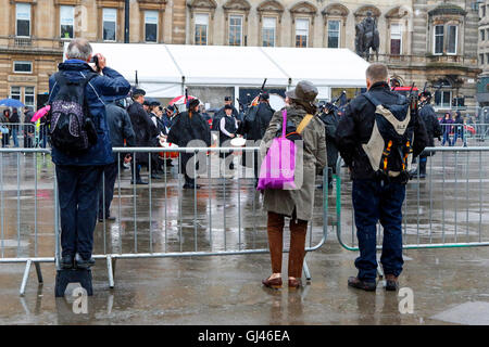 Glasgow, UK. 12. August 2016. Trotz starkem Regen und starkem Wind einige Touristen noch stellte sich heraus, dass die Pipe Bands, gab kostenlose Konzerte auf dem George Square und rund um die Innenstadt zu unterstützen. Die einwöchige Festival der Dudelsack Musik endet am Samstag mit dem spektakulären Welt Pipeband Meisterschaft, an der alle Bands. Credit: Findlay/Alamy leben Nachrichten Stockfoto