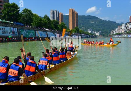 Enshi, Chinas Provinz Hubei. 13. August 2016. Menschen nehmen Teil an einem Drachen Boot Wettbewerb in den Gongshuihe-Fluss in Xuan'en County von Enshi, Zentral-China Hubei Provinz, 13. August 2016. Verschiedene Wassersportarten wie Drachen Boot Contest und Wasser-Volleyball fanden in den Fluss bringen kühle, die lokale Bevölkerung statt. Bildnachweis: Song Wen/Xinhua/Alamy Live-Nachrichten Stockfoto