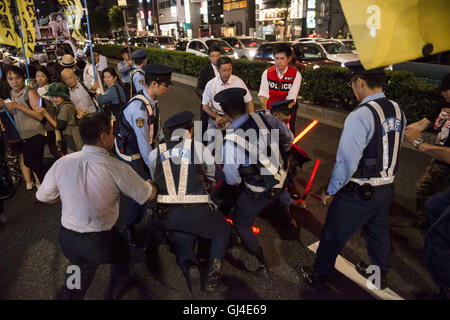 Tokyo, Tokyo, Japan. 13. August 2016. Rechtsextreme Gruppen versuchen, eine Gruppe von Koreanern zu blockieren, die gegen die Regierung Abe und für Frieden demonstriert haben, wollen die Demonstranten symbolisch mit Kerzen die Dunkelheit des Shinto Yasukuni Tempel Leuchten wo Kriegsverbrecher begraben sind. Bildnachweis: Alessandro Di Ciommo/ZUMA Draht/Alamy Live-Nachrichten Stockfoto