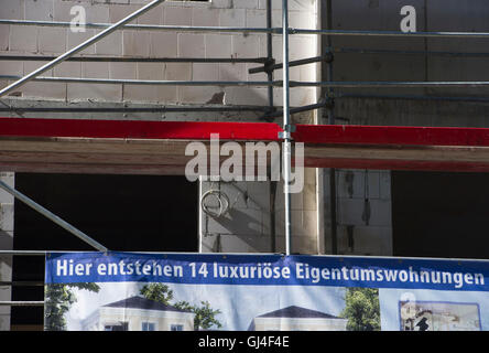 Berlin, Deutschland. 11. August 2016. "Hier Entstehen 14 Luxurioese Eigentumswohnungen" (lit.) "14 luxuriöse owned Immobilie Wohnungen hier entstehen") steht auf ein Banner auf einer Baustelle im Bezirk Treptow in Berlin, Deutschland, 11. August 2016. Foto: PAUL ZINKEN/Dpa/Alamy Live News Stockfoto