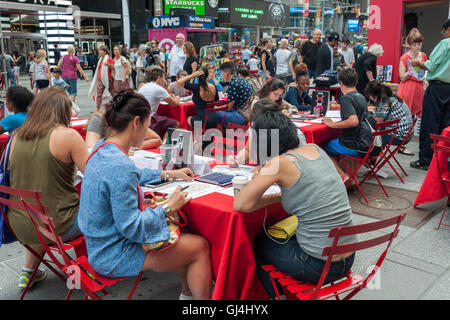 Besucher zum Times Square in New York am Dienstag, 2. August 2016 nutzen Sie kostenlose Malbücher und Lieferungen mit freundlicher Genehmigung von Strand Bookstore. Aufpasser aus echten Kunsttherapeuten verteilt, die Lieferungen für Künstler die beliebte kulturelle Phänomene nutzen. (© Richard B. Levine) Stockfoto