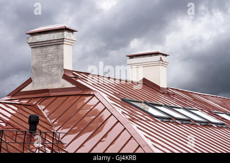 neue rote Metall-Dach mit Oberlichtern und Schornsteine Stockfoto