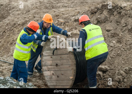 Arbeitnehmer ziehen Roll Hochspannung Kabel-Linie Stockfoto