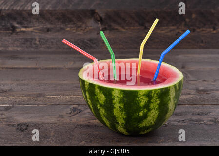 Wassermelonen-Smoothie mit einem Strohhalm auf rustikalen Tisch Stockfoto