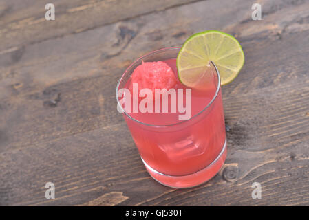 Wassermelone und Limette Saft mit Eiswürfeln auf rustikalen Holztisch Stockfoto