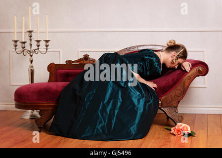 Viktorianische Frau weinend auf couch Stockfoto