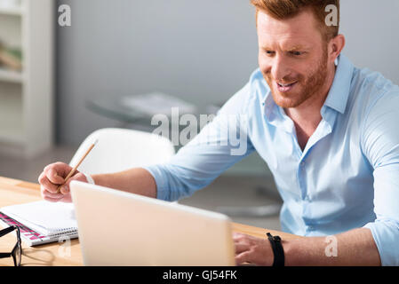 Fröhlicher Mensch am Tisch sitzen Stockfoto