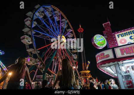 Hell erleuchtete Riesenrad und Karnevalsfahrten sind farbenfrohe nächtliche Attraktionen am Ende des Sommerlandschaftsmesse in Cecil Co., Maryland, USA. Stockfoto