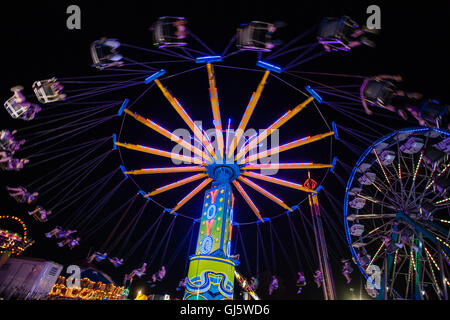 Hell erleuchtete Riesenrad und Karnevalsfahrten sind farbenfrohe nächtliche Attraktionen am Ende des Sommerlandschaftsmesse in Cecil Co., Maryland, USA. Stockfoto