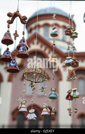 Engel und Glocken mobile Souvenirs zum Verkauf an dieser Straße stand in auf ein outdoor-Markt, mit der orthodoxen Kirche des Hl. Stockfoto