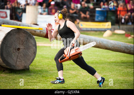 Eine Frau Konkurrent im offenen offenen Hindernis Ruckeln Ereignis.  Die Squamish Holzfäller Tag Logger Sport-Event.  Weibliche Logger mit einer Kettensäge. Stockfoto