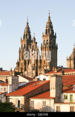 Westfassade von Santiago De Compostela bei Sonnenuntergang. Beachten Sie Kerl auf Dach Spektakel am 24. Juli Feuerwerk vorbereiten. Tausende von Besucher und Pilger versammeln sich in Santiago De Compostela, St James Day zu feiern. 25. Juli ist St James Day, dem Schutzpatron von Spanien. Die Kathedrale ist der angeblichen Grabstätte von St James das große, einer der Apostel Jesu Christi und der Schutzpatron von Spanien. Die Kathedrale ist das berühmte Ziel von Wallfahrten in ganz Europa, dem Camino de Santiago, an diesen Ort in Galicien im Nordwesten von Spanien. Stockfoto