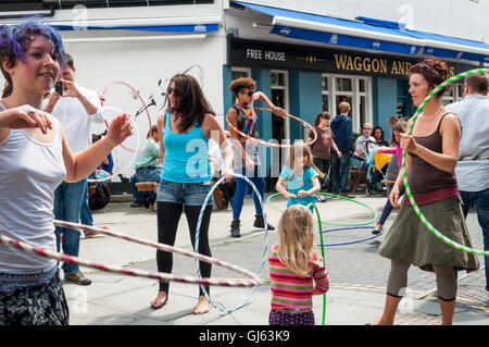 Brighton, East Essex, Großbritannien, England, Mädchen, Menschen, spielend, Hula Hoops, Straße, Blick, urban, vollgepackt, überfüllt, Menschenmenge, Brighton Festival Stockfoto