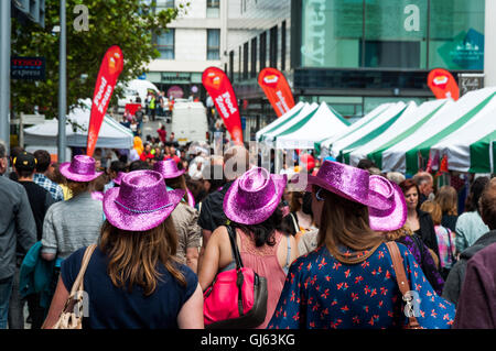 Menschenmenge und Gruppe von Frauen mit rosa Hüten in der Jubilee Street während des Brighton Festivals in Brighton, East Essex, Großbritannien, ab 2012 Stockfoto