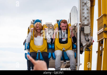 Pärchen, die auf dem Booster am Pier von Brighton, Brighton, Großbritannien, lustige Mimik machen, ab 2012 Stockfoto