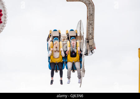 Pärchen, die auf der Achterbahn Booster auf dem Pier von Brighton, Brighton, Großbritannien, lustige Mimik machen, ab 2012 Stockfoto