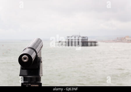 Touristenteleskop mit Blick auf den alten Westpier in Brighton, East Sussex, Großbritannien ab 2012 Stockfoto