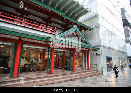 Entlang der Omotesando Avenue sind die roten "Oriental Bazaar", das traditionelle japanische Souvenirs neben dem Milchglas Dior verkauft Stockfoto