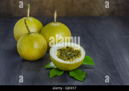 Frische Passionsfrucht und die Hälfte über hölzerne Hintergrund, Stillleben Stockfoto