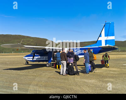 dh kleine Turboprop Flugzeug MESSE ISLES FLUGHAFEN MESSE ISLE SCHOTTLAND Abfliegende Passagiere Menschen an Bord geparkten islander Flugzeug Start-und Landebahn Stockfoto