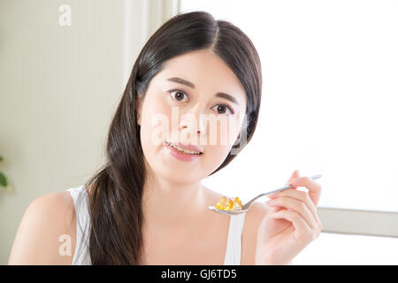 junge schöne asiatische Frau Nahrungsergänzungsmittel Pille für gesunden Lebensstil zu Hause essen