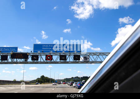 Schwerlastverkehr auf der M25 Autobahn gegen den Uhrzeigersinn Blick nach Süden zwischen den Anschlussstellen 15 und 16, in der Nähe von Heathrow Airport in England Stockfoto