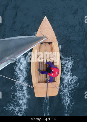 Blick nach unten von oben des Mastes Flitzer Klasse Segeln Jolle mit männlichen Helm in den Sechzigern Stockfoto