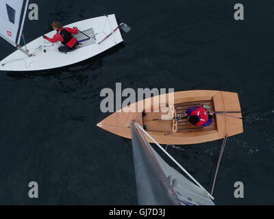 Blick nach unten von oben des Mastes Flitzer Klasse Segeln Jolle mit männlichen Helm in den Sechzigern Stockfoto