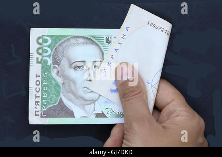 ukrainische Geld, Hand mit Geld, schwarzer Hintergrund, halten Geld, fünfhundert Griwna, ukrainische Währung, finanzielle situation Stockfoto