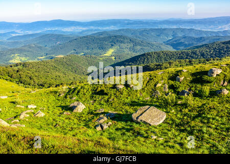 Berglandschaft mit Steinen Verlegung unter dem Rasen oben auf dem Hügel unter dem bewölkten Sommerhimmel Stockfoto