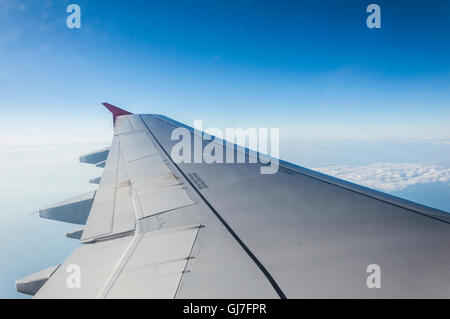 Blick durch Fenster Flugzeug während des Fluges im Flügel mit einem schönen blauen Himmel Stockfoto