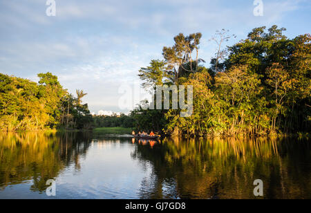 Ein Kanu mit Touristen über Amazon bei Sonnenuntergang paddeln. Yasuni-Nationalpark in Ecuador, Südamerika. Stockfoto