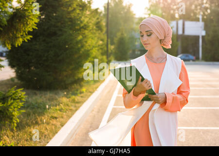 Junge muslimische Asiengeschäft Frau lächelnd und hält Dateidokument Stockfoto