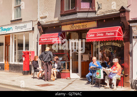 Leute sitzen in der Sonne draußen Browns in Church Street, Barmouth, Gwynedd, Wales, UK Stockfoto