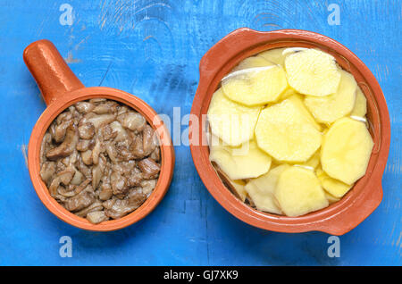 Gebratene Pilze und gehackte rohe Kartoffeln Stockfoto