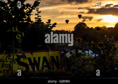 Bristol, UK. 13. August 2016. Die Masse Besteigung des Bristol Balloon Fiesta Festival startet schließlich nach Verzögerungen aufgrund von starkem Wind seit Donnerstag. Ein atemberaubender Sonnenuntergang diente als Kulisse für mehrere Ballons in den Himmel nahm, nachdem Festivalorganisatoren gab grünes Licht für Lift ab. Die Ballons trieben über der Stadt Bristol in Richtung Weiler von Bitton und Keynsham vor der Landung in Zufallsfelder und Parkland viele Meilen vom Festivalgelände Ashton Gericht. Bildnachweis: Wayne Farrell/Alamy Live-Nachrichten Stockfoto