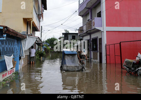 Bulacan, Philippinen. 14. August 2016. Bewohner waten durch das Hochwasser brachte durch den Monsun-Regenfälle in der Provinz Bulacan, den Philippinen, 14. August 2016. Mindestens fünf Menschen wurden getötet und mehr als 70.000 Personen durch Monsunregen, die betroffenen meistens Norden der Philippinen, einschließlich Metro Manila, in den letzten Tagen des Landesamtes Disaster Management sagte am Sonntag vertrieben wurden. Bildnachweis: Rouelle Umali/Xinhua/Alamy Live-Nachrichten Stockfoto