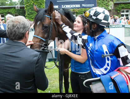 Hoppegarten, Deutschland. 14. August 2016. Trainer Andreas Wolf (l) gibt dem richtige Pferd protektionistische etwas Wasser zu trinken, Tto das Recht jockey Eduardo Pedroza und Minder Kira 126. Grosser Preis von Berlin in Hoppegarten, Deutschland, 14. August 2016. Foto: Jörg CARSTENSEN/Dpa/Alamy Live News Stockfoto