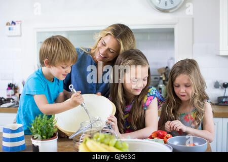 EIGENTUM FREIGEGEBEN. -MODELL VERÖFFENTLICHT. Mutter und Sohn und Töchter Kochen in der Küche. Stockfoto