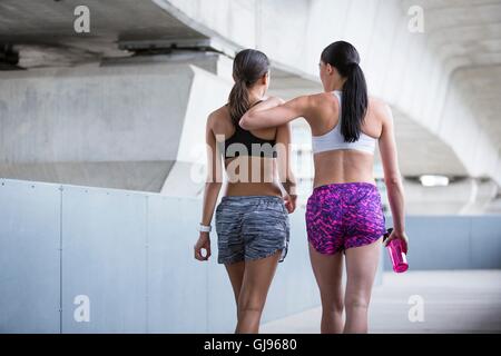-MODELL VERÖFFENTLICHT. Zwei junge Frauen im Sport tragen zu Fuß entfernt. Stockfoto