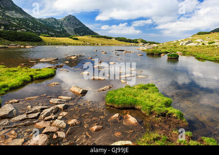 Gletschersee reflektieren die weißen Wolken am Himmel, Retezat-Gebirge, Rumänien Stockfoto