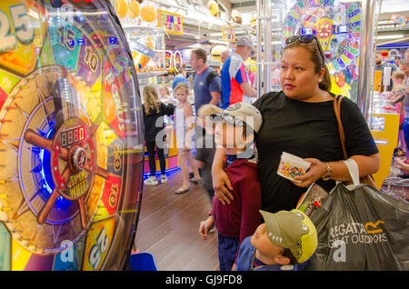 Eine junge Familie ein Spiel "am Rad drehen" in eine Spielhalle. Stockfoto