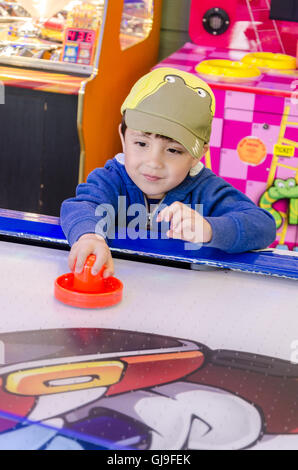 Ein kleiner Junge spielt Luft in eine Spielhalle. Stockfoto