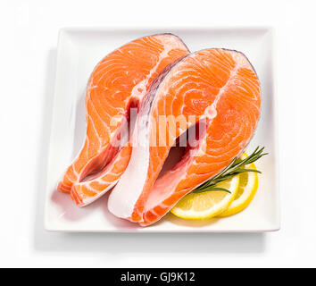 Zwei Scheiben Lachs Steak mit Zitrone und Rosmarin auf weiße, Top Sicht Stockfoto